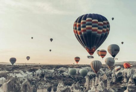 Nightlife Experience Cappadocia - Multicolored hot air balloons flying above famous vast rocky valley in Cappadocia Turkey on early morning on fair weather
