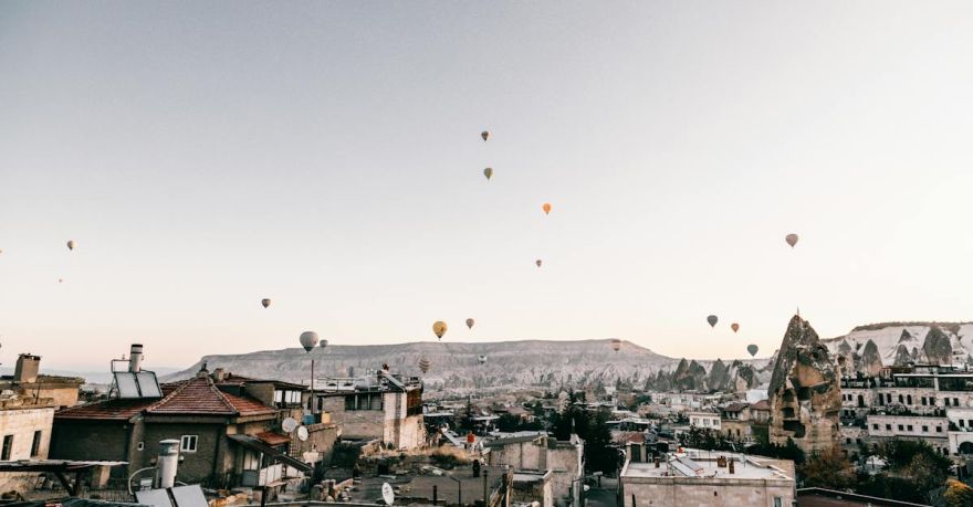 Rooftop Dining Cappadocia - Hot air balloons flying over picturesque town