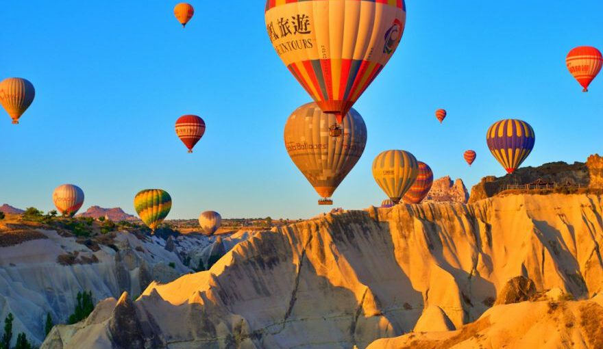 Cappadocia Cherry Picking - a group of hot air balloons flying in the sky