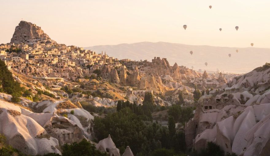 Village Experience Cappadocia - a group of hot air balloons flying over a rocky landscape