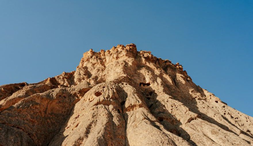Explore Cappadocia Cappadocia - a rocky mountain with a blue sky