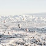 Family Travel Cappadocia - assorted-color air balloons below snowland at daytime