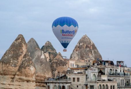 Turkish Spirits Cappadocia - a blue and white hot air balloon flying over a city