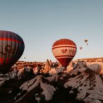 Photography Contest Cappadocia - red and black hot air balloon flying over the mountain