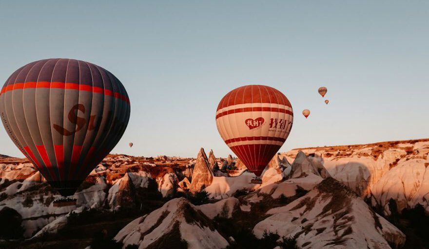 Photography Contest Cappadocia - red and black hot air balloon flying over the mountain