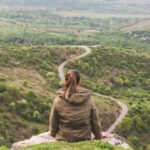 Cappadocian Frescoes Visual Journey - woman sitting on grey cliff