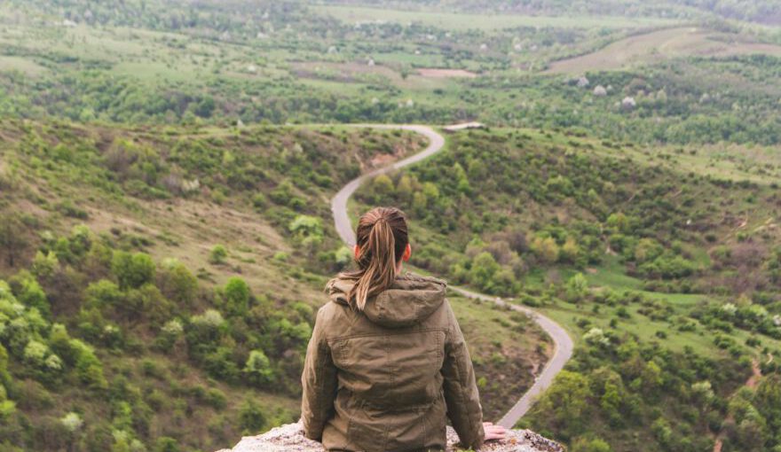 Cappadocian Frescoes Visual Journey - woman sitting on grey cliff