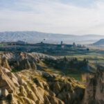 Meze Spreads Cappadocia - Hot Air Balloon Flying over the Brown Rocky Mountains