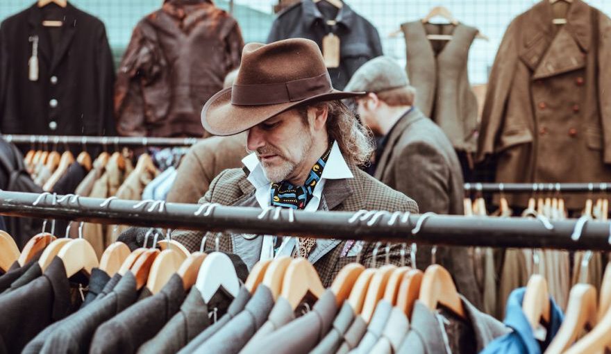 Charming Shopping Ürgüp - man in brown cowboy hat in front of hanged suit jackets