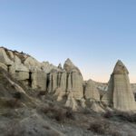 Cappadocia Pigeon Lofts - a group of tall rocks sitting on top of a hillside