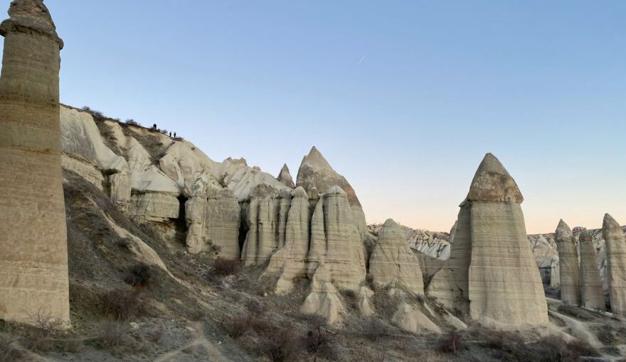 Cappadocia Pigeon Lofts - a group of tall rocks sitting on top of a hillside