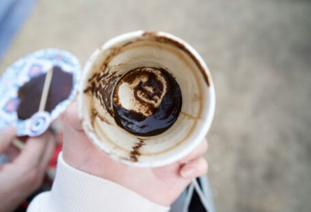 Turkish Coffee Divination - a person holding a cup with a chocolate swirl in it