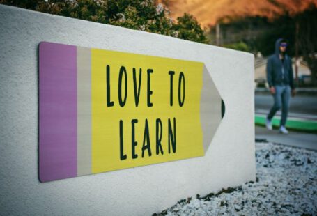 Learning Language - love to learn pencil signage on wall near walking man